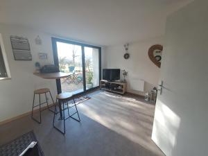 a living room with a table and chairs and a television at Les Glycines in Salles-la-Source