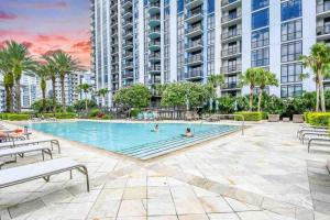 a swimming pool in a building with two people swimming at The perfect gateway with magical views in DT ORL in Orlando