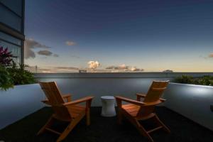 2 sillas en un balcón con vistas al océano en Trendy Gateway by Lake Eola Free Parking en Orlando