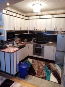 a kitchen with white cabinets and a stove top oven at Apartment Deluxe Holiday in Bihać