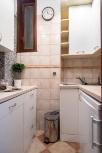 Una cocina con un fregadero y un reloj en la pared. en Convenient apartment in the heart of downtown, en Budapest 20 fotos más