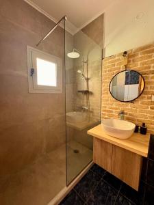 a bathroom with a sink and a glass shower at Summerscape Studios and Apartments in Corfu +32 photos