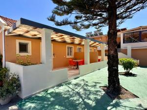 a view of a house with a tree in the yard at Summerscape Studios and Apartments in Corfu