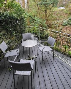 una mesa y sillas en una terraza de madera en Woodlands, en Windermere