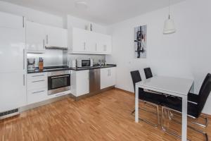 a kitchen with white cabinets and a table and chairs at Apartment Isabella in Berlin