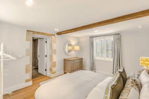 a bedroom with a large bed and a window at Washbrook Cottage - Hot Tub Packages Available in Little Compton