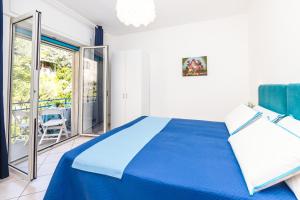 een slaapkamer met een blauw bed en een balkon bij Casa del pescatore in Sorrento