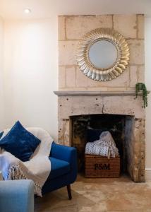 a living room with a blue chair and a mirror at Seven Acres Cottage with Parking in Bath