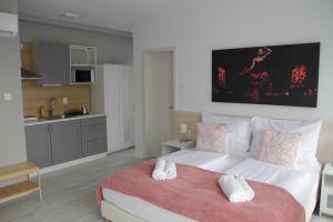 a bedroom with a large bed and a kitchen at ****Heviz Springs Apartments in Hévíz