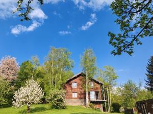an old brick house in a field with trees at Šumarak Lodge in Sarajevo