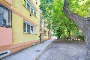 um edifício com uma árvore ao lado de uma rua em Cozy Home - Close to River - Easy Parking em Budapeste