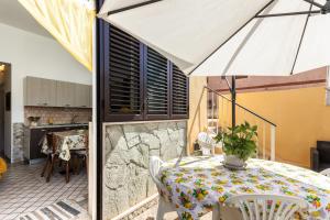 ein Esszimmer mit einem Tisch und einem Sonnenschirm in der Unterkunft Casa Pazza in Avola