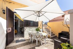 einen Tisch mit einem weißen Regenschirm auf einer Terrasse in der Unterkunft Casa Pazza in Avola