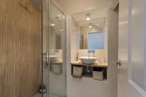 een badkamer met een glazen douche en een wastafel bij Setúbal Terrace apartments in Setúbal