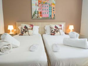2 bedden in een kamer met witte lakens en kussens bij SEAgull apartments in Néa Péramos