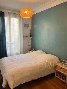 Un pat sau paturi într-o cameră la Élégant Appartement Bohème 11e