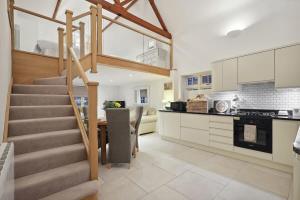 a kitchen and dining room with a staircase and a table at Squirrel Lodge - 2 Bed Country Home in Market Harborough