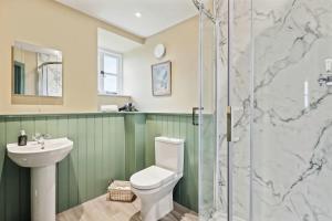 La salle de bains est pourvue de toilettes, d'un lavabo et d'une douche. dans l'établissement Sophie's Barn - Hot Tub Packages Available, à Market Harborough