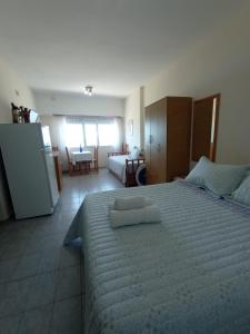a bedroom with a large bed and a room with a kitchen at Abanico in Puerto Madryn