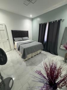 a bedroom with a bed and a black curtain at Faith moves mountains in Ocho Rios