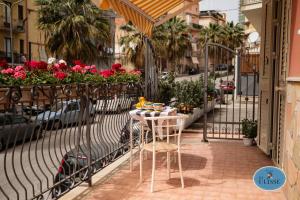a table and chairs on a balcony with flowers at Le Dimore di Ulisse a Gela - Casa vacanza B&B - La casa di Ulisse in Gela