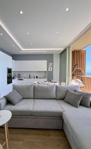 a living room with a large couch and a kitchen at Royal Paradise Green Coast Resort Palase in Vlorë