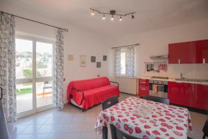 a kitchen with red cabinets and a red couch in it at Lacona Mare by HelloElba in Lacona