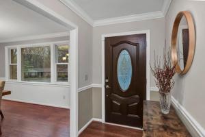 a hallway with a brown door and a vase of flowers at The Quails Nest of Harbison in Columbia