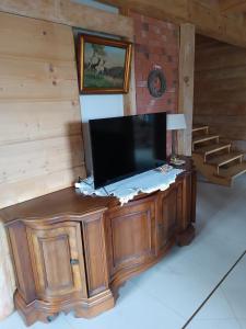 TV de pantalla plana en la parte superior de un armario de madera en Wczasowisko Rudawski Zakątek en Wieściszowice