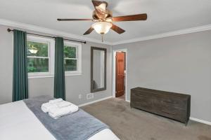 a bedroom with a ceiling fan and green curtains at The Quails Nest of Harbison in Columbia