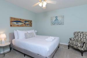 a bedroom with a white bed and a chair at The Quails Nest of Harbison in Columbia