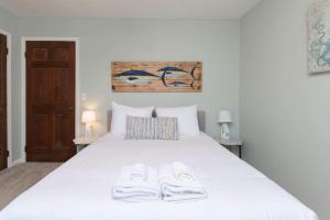 um quarto com uma cama branca com duas toalhas em The Quails Nest of Harbison em Columbia
