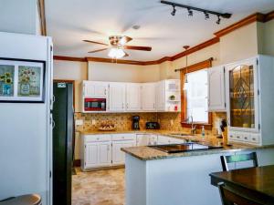 a kitchen with white cabinets and a ceiling fan at Serenity in the Suburbs in Columbia