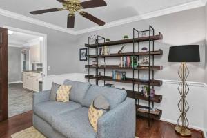 a living room with a blue couch and a book shelf at The Quails Nest of Harbison in Columbia