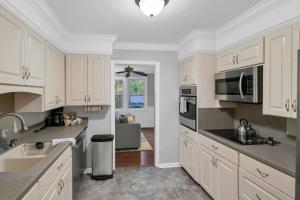 a kitchen with white cabinets and stainless steel appliances at The Quails Nest of Harbison in Columbia