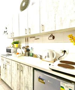 eine Küche mit weißen Schränken und einem Waschbecken in der Unterkunft דירה רומנטית ברחוב בוגרשוב ליד הים in Tel Aviv