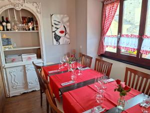 Malvaglia的住宿－Ristorante Notari cà di gust vecc，一间带红色桌布的餐桌的用餐室