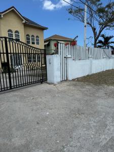 a white fence in front of a house at Faith moves mountains in Ocho Rios