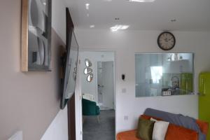 een woonkamer met een bank en een klok aan de muur bij Stylish 1 Bed Apartment 5, free parking 5 mins to CityCentre in Birmingham