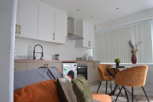 een woonkamer met een bank en een keuken bij Stylish 1 Bed Apartment 5, free parking 5 mins to CityCentre in Birmingham