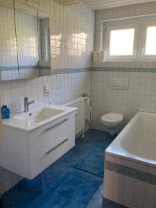 a bathroom with a sink and a tub and a toilet at FeWo 49 in Goldkronach
