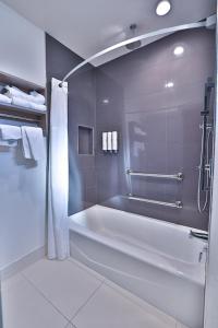 y baño blanco con bañera y ducha. en Hotel Miramar, en San Clemente