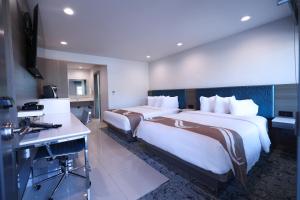 a hotel room with two beds and a desk at Hotel Miramar in San Clemente