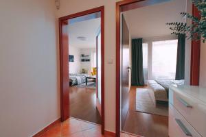 a room with a mirror and a living room at Apartmán u METRA, 4 hosté, parking free, blízko O2 arena in Prague