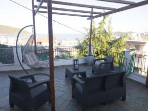 Un patio con sillas y una hamaca en el balcón. en SEAgull apartments en Néa Péramos