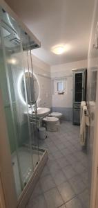 een badkamer met 2 toiletten en een glazen douche bij LUCKY HOME CITTÀ ALTA in Bergamo