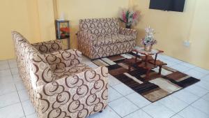 a living room with two couches and a table at Faith & Peace Guest House in Fontenoy