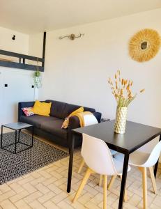 a living room with a black table and a couch at Appartement climatisé à deux pas de la plage in Port Leucate