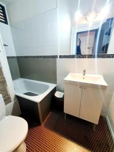 a bathroom with a sink and a tub and a toilet at Appartement climatisé à deux pas de la plage in Port Leucate