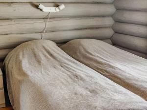 ein Bett mit einer Decke an der Wand in der Unterkunft Holiday Home Vahtamantie 8 b by Interhome in Saariselkä